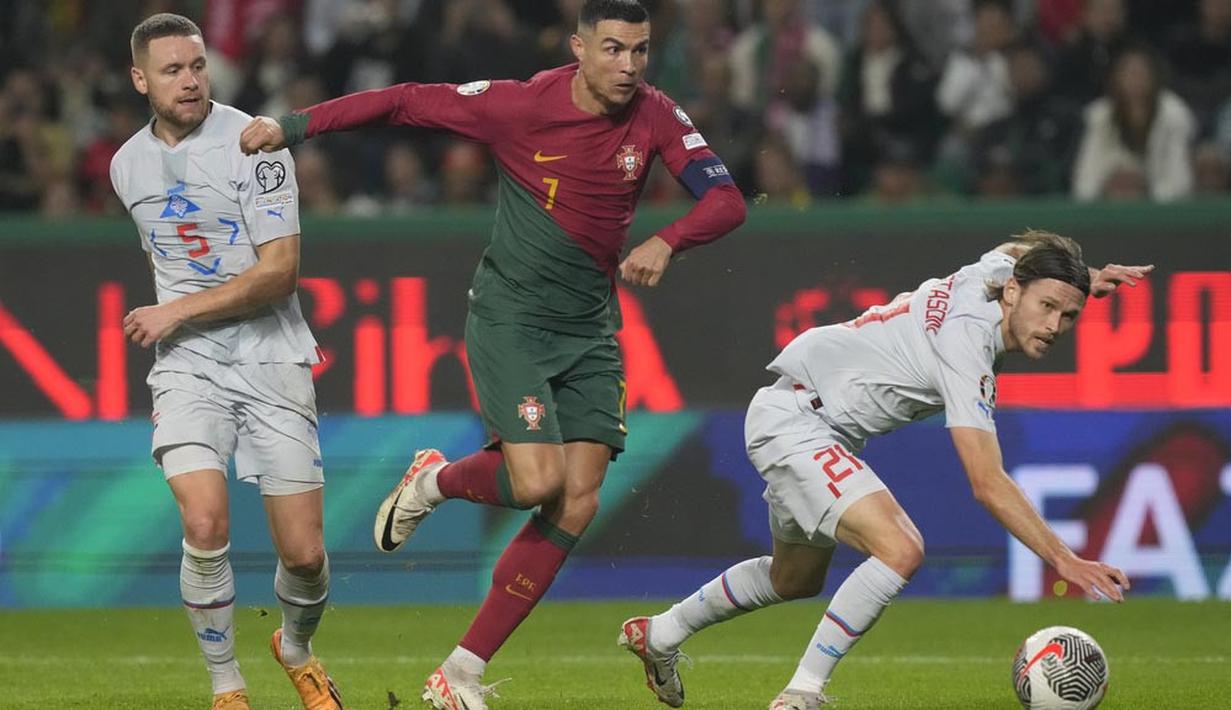 Pemain Portugal, Cristiano Ronaldo, berusha melewati pemain Islandia, Sverrir Ingi Ingason dan Arnor Ingvi Traustason pada Kualifikasi Euro 2024 di Stadion Alvalade, Senin (20/11/2023). Kemenangan ini memastikan laju sempurna Portugal untuk finis sebagai juara Grup J dengan 30 poin dari 10 pertandingan. (AP Photo/Armando Franca)