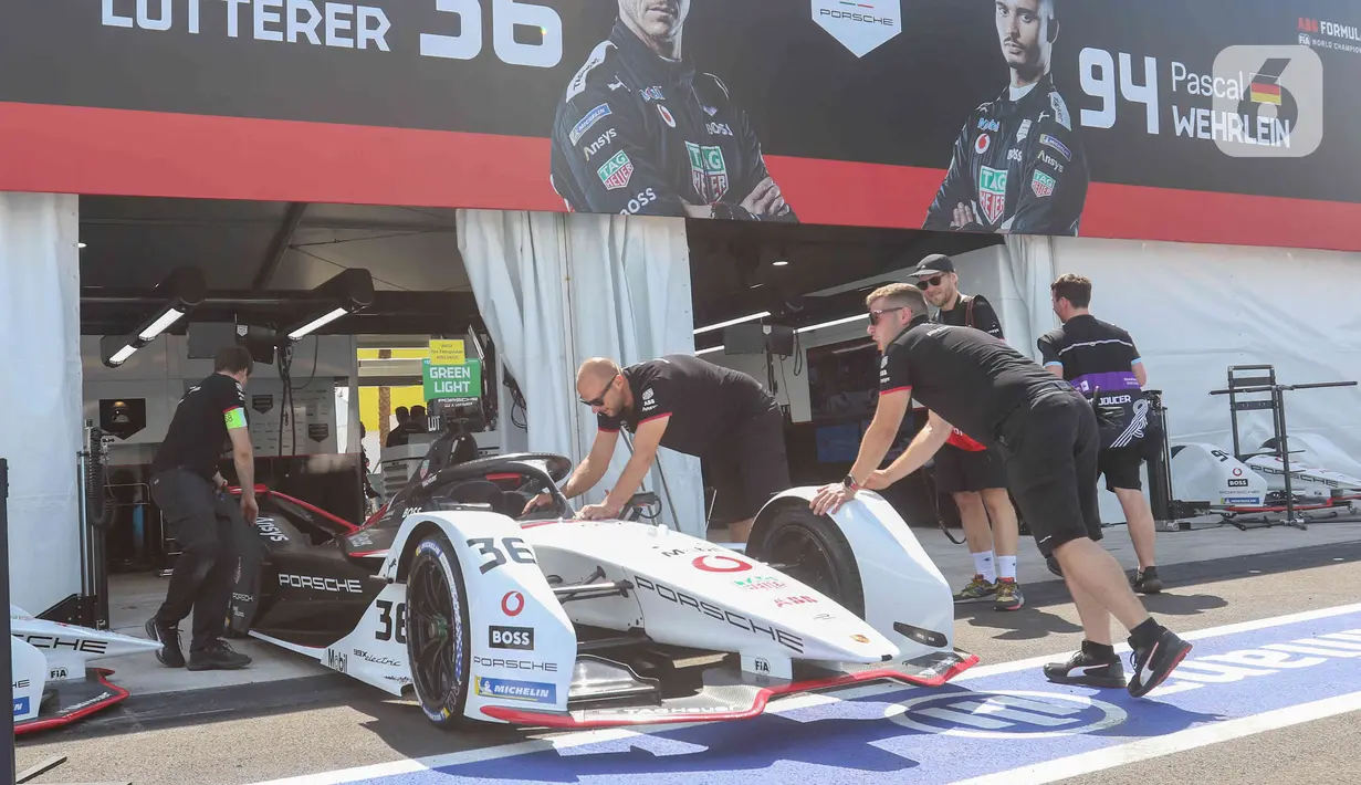 Kru tim peserta lomba balap melakukan persiapan mobil listrik Formula E  di pit Jakarta International E-Prix Circuit (JIEC), Jakarta, Jumat (3/6/2022). Menjelang pertandingan Formula E pada besok hari (4/6/2022) kru tim pembalap melakukan persiapan mobil listrik Formula E. (Liputan6.com/Herman Zakharia)