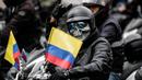 Seorang pengendara sepeda motor memberi isyarat selama protes kenaikan harga bahan bakar di Bogota, Kolombia, Rabu (12/10/2022). Aksi protes ini muncul karena kenaikan harga bahan bakar dan asuransi wajib pihak ketiga. (AP Photo/Ivan Valencia)