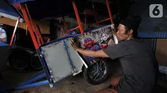 Asep saat hendak menempelkan stiker ondel-ondel pada bodi odong-odong buatannya di Jakarta, Rabu (30/10/2019). Industri rumahan milik Asep Kohar (48) itu sudah 8 tahun memproduksi odong-odong, baik jenis mainan anak maupun kereta mini yang terdiri atas 3 rangkaian. (merdeka.com/Iqbal S. Nugroho)