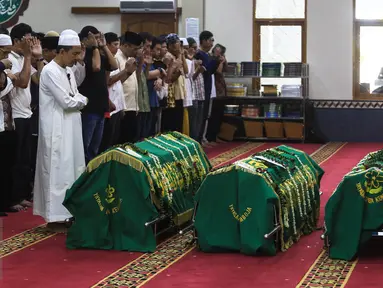 Warga dan kerabat menyolatkan tiga jenazah korban pembunuhan sadis Pulomas di Masjid At Taubah, Pulomas, Kayuputih, Jakarta, Rabu (28/12). Tiga jenazah yaitu Dodi Triono (59) serta dua putrinya Diona Arika dan Dianita Gemma. (Liputan6.com/Faizal Fanani)