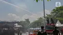 Petugas pemadam kebakaran melakukan penyiraman air ke tenda para pemudik motor di Pelabuhan Ciwandan, Banten, Minggu (7/4/2024). (Liputan6.com/Angga Yuniar)