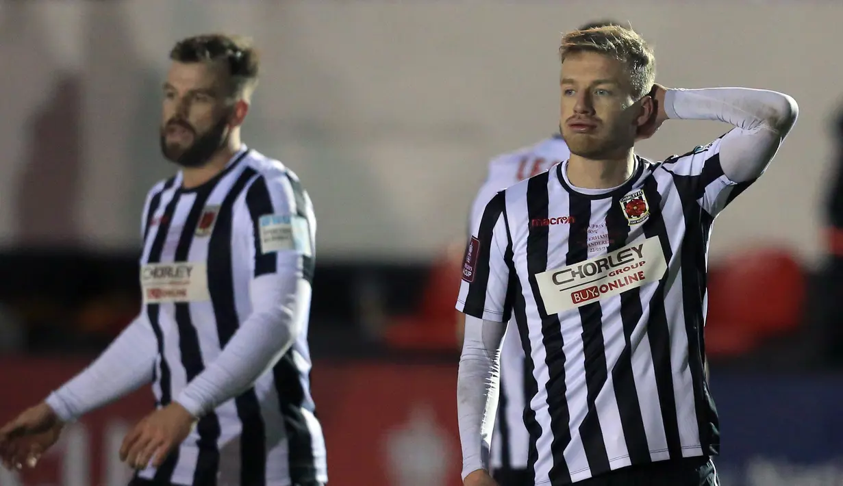 Dua pemain Chorley, bek Andy Halls (kiri) dan gelandang Elliot Newby tampak kecewa usai dikalahkan Wolverhampton Wanderers 0-1 dalam laga babak keempat Piala FA 2020/21 di Victory Park Stadium, Jumat (22/1/2021). (AFP/Lindsey Parnaby)