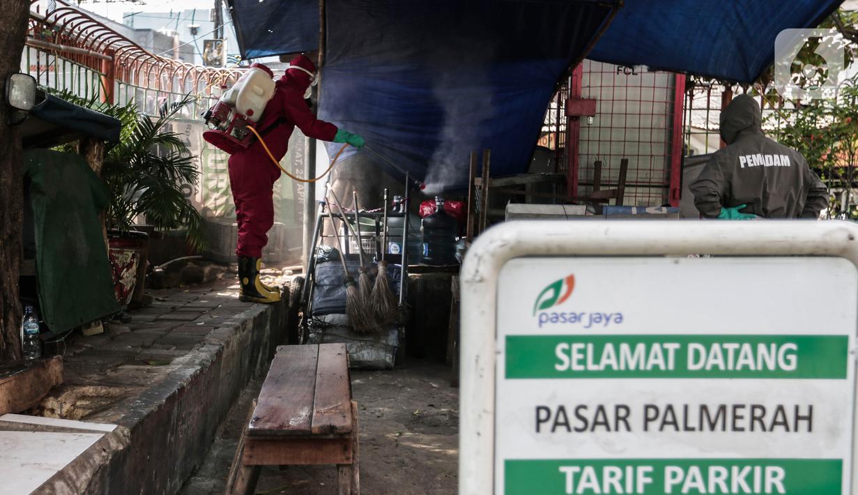 Petugas menyemprotkan Cairan Disinfektan di Pasar Palmerah, Jakarta, Kamis (25/6/2020). Pada hari ini pasar pelmerah resmi ditutup selama 3 hari kedepan dikarenakan 9 pedagang dinyatakan positif Covid-19. (Liputan6.com/Johan Tallo)