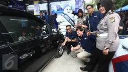 Presdir. PT Michelin Indonesia Pascal Nouvellon (ketiga kanan) dan Kasubdit Dikyasa Ditlantas Polda Metro Jaya AKBP Agustin Susilowati saat mengisi ban mobil di Jakarta, Rabu (15/6). (Liputan6.com/Angga Yuniar)