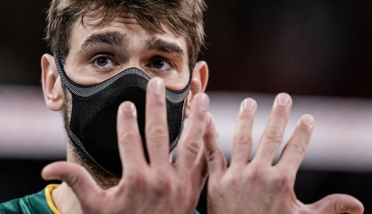 Pevoli Brasil, Lucas Saatkamp memberi isyarat saat babak penyisihan grup B bola voli putra Olimpiade Tokyo 2020 Brasil dan AS di Ariake Arena pada 30 Juli 2021. Lucas Saatkamp mengaku menggunakan masker saat berlaga demi melindungi dirinya dan keluarganya dari Covid-19. (AP/Manu Fernandez)