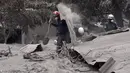 Tim penyelamat membongkar atap rumah warga untuk mencari korban dari letusan gunung Feugo di desa San Miguel Los Lotes, Guatemala (5/6). Hingga kini dilaporkan, sedikitnya 69 orang tewas akibat letusan gunung Feugo. (AFP/Johan Ordonez)