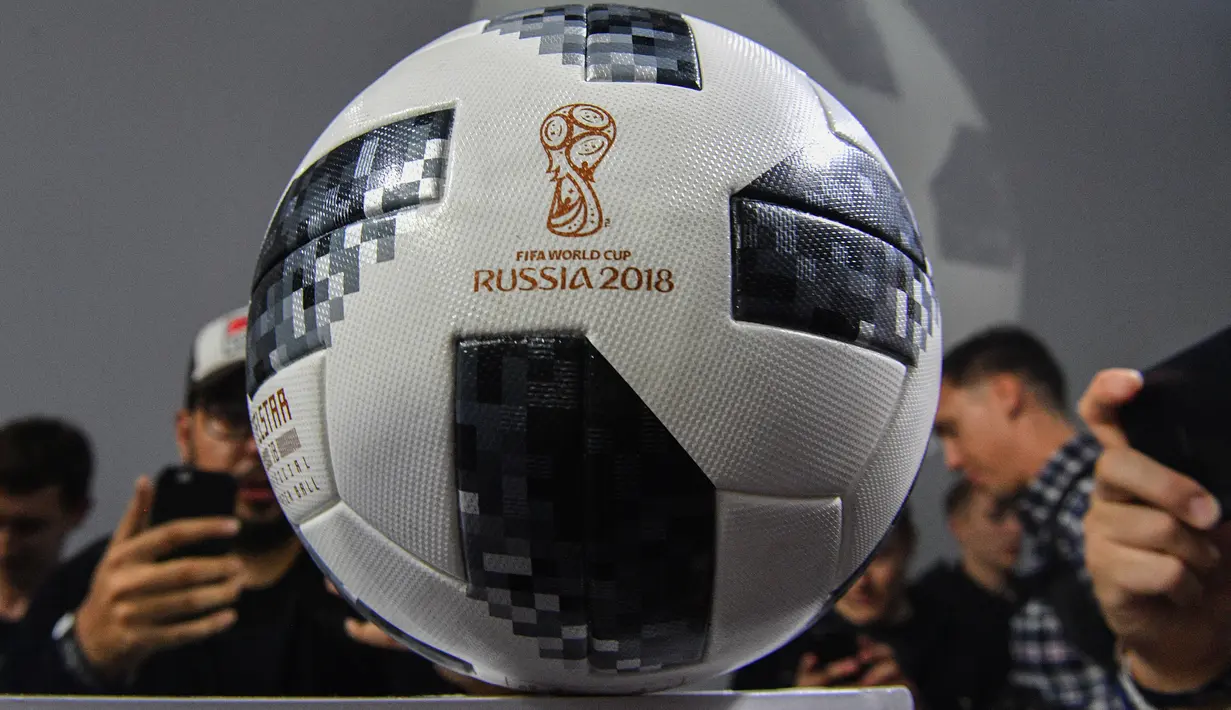 Peserta memotret Telstar 18, bola resmi Piala Dunia 2018 Rusia, dalam acara di Moskow, Kamis (9/11). Telstar 18 didesain dengan tampilan panel hitam, serta perpaduan gradasi warna hitam-putih seperti dalam siaran televisi era 70-an. (Mladen ANTONOV/AFP)