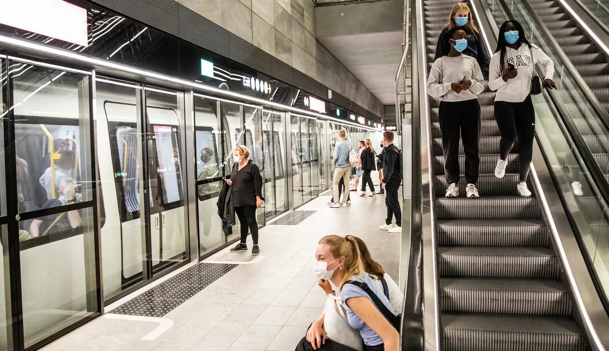 Orang-orang yang memakai masker menunggu di platform metro di Kopenhagen Sabtu (22/8/2020) dini hari. Pemerintah Denmark telah mewajibkan pemakaian masker di semua angkutan umum untuk mencegah penyebaran Covid-19 mulai Sabtu (22/8) ini.  (Olafur Steinar Rye Gestsson/Ritzau Scanpix via AP)