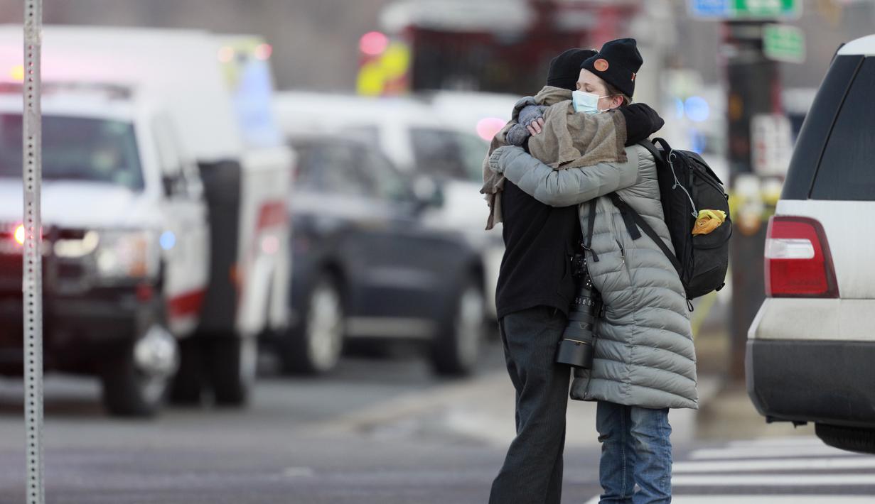 Wanita berpelukan di sudut Broadway dan Table Mesa Drive dekat toko King Soopers tempat penembakan terjadi di Boulder, Colorado (22/3/2021). Aksi penembakan tersebut terjadi di pusat perbelanjaan King Soopers di Kota Boulder, Colorado, Amerika Serikat. (AP Photo/Joe Mahoney)