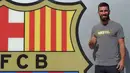 Arda Turan mengacukan ibu jari ke awak media saat sesi perkenalan di luar Stadion Camp Nou, Barcelona, Spanyol, (9/7/2015). Pemain kelahiran 30 Januari 1987 resmi di kontrak  Barcelona hingga lima tahun ke depan. (AFP PHOTO/Lluis GENE)