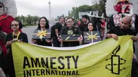 Aktivis yang tergabung dalam Amnesty Internasional Indonesia menggelar aksi di depan Istana Negara, Jakarta, Selasa (10/12/2019). Aksi tersebut digelar untuk memperingati Hari HAM Sedunia 2019. (Liputan6.com/Faizal Fanani)