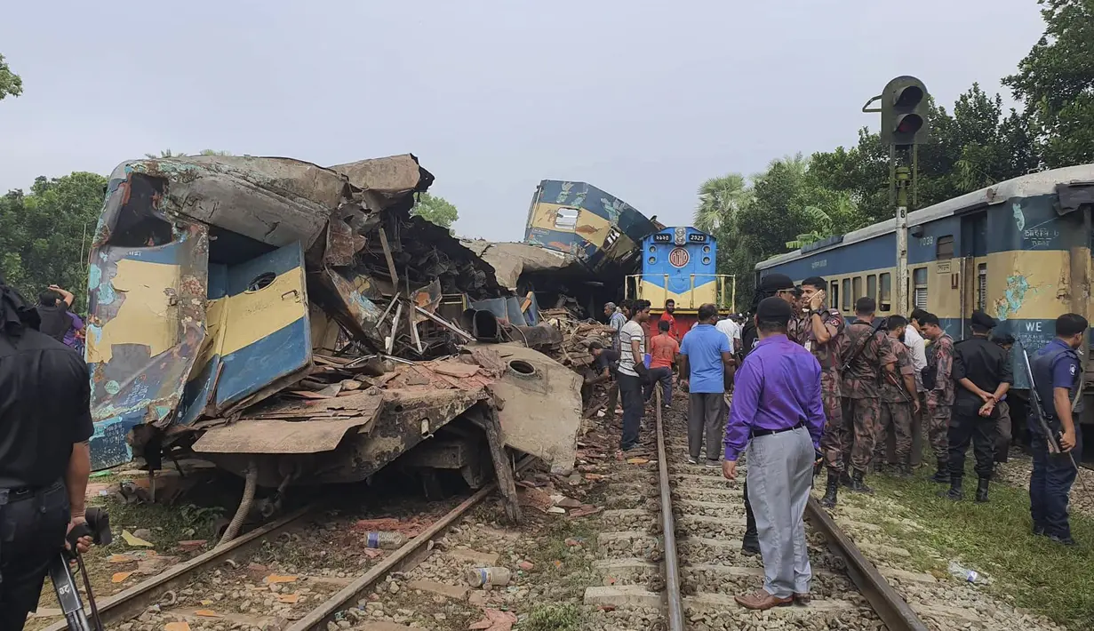 Orang-orang berkumpul di dekat gerbong kereta yang rusak parah setelah dua kereta yang melaju bertabrakan di distrik Brahmanbaria, 82 kilometer (51 mil) timur ibukota, Dhaka, Bangladesh, Selasa (12/11/2019). Sekitar 16 orang tewas dan 60 lainnya terluka akibat kecelakaan tersebut. (AP Photo)
