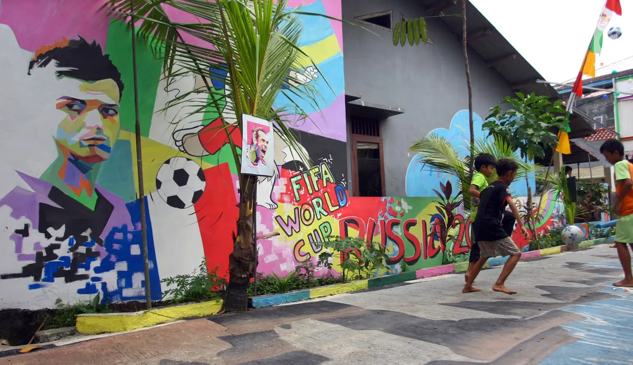 Anak-anak bermain bola di sebuah gang di Kinayungan, Tangsel, Kamis (28/6). Warga di perumahan tersebut menghias lingkungannya menjadi "Kampung Piala Dunia" guna menyemarakan perhelatan sepak bola Piala Dunia 2018 di Rusia. (Merdeka.com/ Arie Basuki)