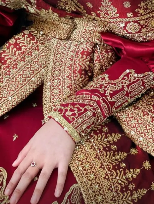 Dress dengan warna dasar merah ini dihiasi bordir emas yang membuat penampilan Putri Iriani semakin megah nan mewah. [Foto: Instagram/tiffanyliemstudio]