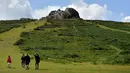 Orang-orang berjalan ke Haytor Rocks di Taman Nasional Dartmoor, dekat Exeter, Inggris barat daya, (12/8/2019). Kawasan ini dilindungi sebagai Taman Nasional, dengan luas sekitar 954 kilometer persegi (368 sq mi). (AFP Photo/Ben Stansall)