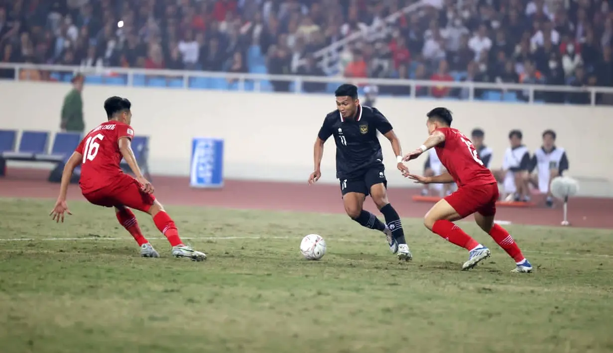 Pemain Timnas Indonesia Dendy Sulistyawan (tengah) menggiring bola mencoba melewati pemain Timnas Vietnam Nguyen Thanh Chung (kiri) dan Nguyen Tien Linh (kanan) pada leg pertandingan kedua babak semifinal Piala AFF 2022 di My Dinh Stadium, Vietnam, Senin (9/1/2023). Indonesia kalah 0-2 dari Vietnam. (Dok. PSSI)