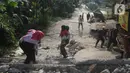 Sejumlah warga melintasi jalan yang terbelah akibat pergeseran tanah di kawasan Bojong Koneng, Babakan Madang, Kabupaten Bogor, Jawa Barat, Jumat (16/9/2022). Badan Penanggulangan Bencana Daerah (BPBD) setempat mencatat 18 unit rumah mengalami kerusakan, dan pergeseran tanah itu menyebabkan retakan-retakan di tanah, dinding, plafon dan lantai rumah warga serta akses jalan sudah tidak bisa dilewati oleh kendaraan roda dua dan roda empat. (Liputan6.com/Herman Zakharia)