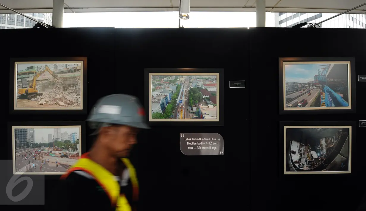 Pekerja melintas di depan deretan foto kemajuan pembangunan MRT yang dipamerkan di JPO Bundaran Hotel Indonesia, Jakarta, Minggu (7/5). Pameran bertema Aku, Kamu, Kita #UbahJakarta. (Liputan6.com/Helmi Fithriansyah)