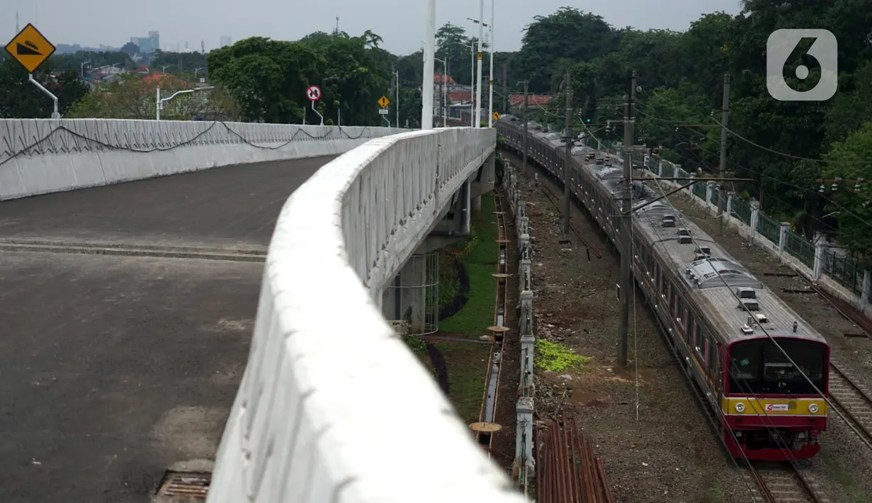 Kereta melintas di samping Flyover Lenteng Agung yang hampir rampung pengerjaannya, Jakarta Selatan, Rabu (4/11/2020). Flyover Lenteng Agung dan Tanjung Barat yang berbentuk tapal kuda tersebut dibangun dengan nilai kontrak Rp 144,4 miliar. (Liputan6.com/Immanuel Antonius)