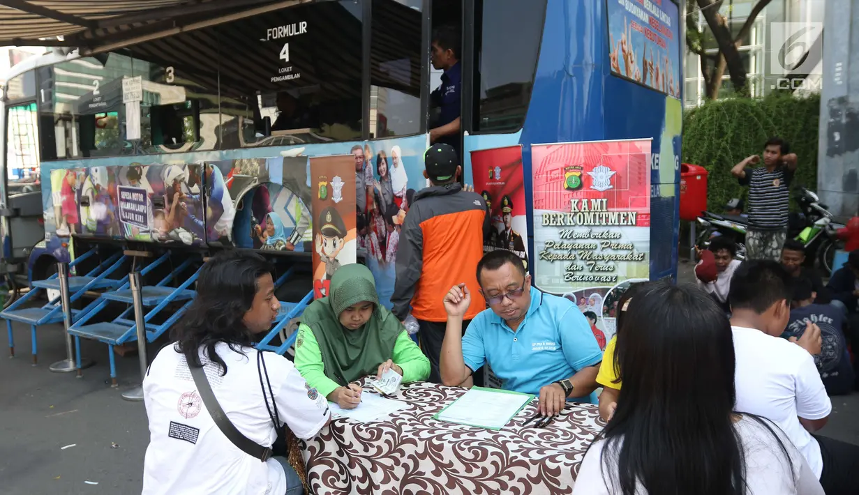 Warga mengisi formulir pajak kendaraan bermotor di gerai Samsat Keliling Car Free Day, Jakarta, Minggu (21/10). Layanan pembayaran pajak Surat Tanda Nomor Kendaraan (STNK) bisa dilakukan tanpa membawa salinan atau BPKB. (Liputan6.com/Angga Yuniar)
