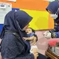Seorang tenaga kesehatan memberikan suntikan imunisasi anak rutin di Posyandu Erma, Kelurahan Ledeng, Cidadap, Kota Bandung, Jawa Barat pada Rabu, 17 Mei 2023. (Dok Liputan6.com/Fitri Haryanti Harsono)