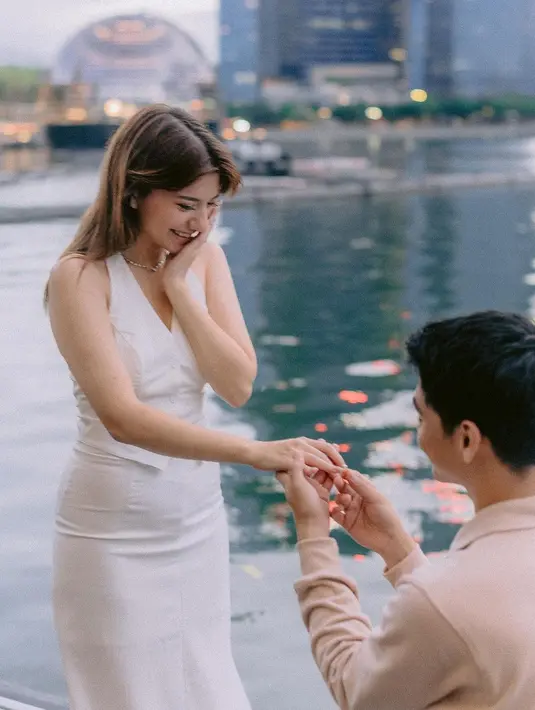 Cassandra Lee padukan vest tanpa lengan dan rok panjang berwarna putih dengan sneakers [@cassandralee]