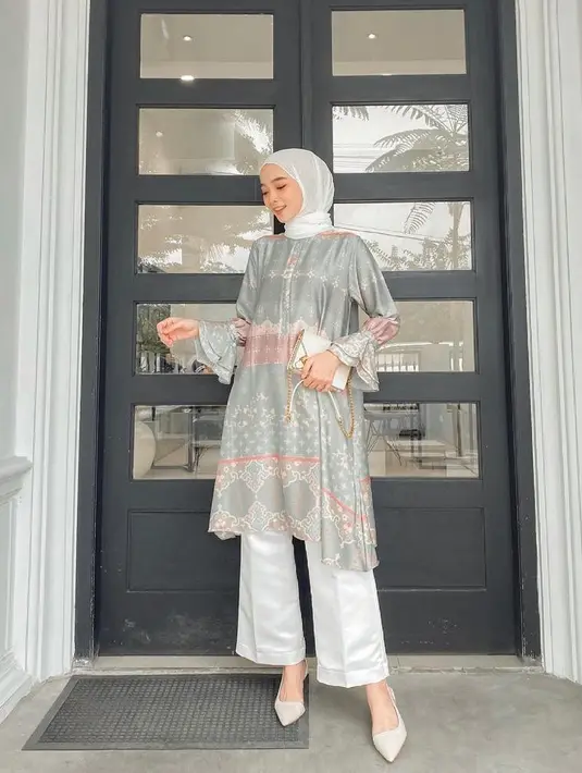 Inspirasi outfit kondangan yang elegan, padukan tunik satin dengan kulot dan hijab warna putih. Tak lupa, tambahkan pula clutch warna senada (Instagram/liza.rosalita).