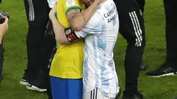 Penyerang Argentina, Lionel Messi memeluk pemain Brasil, Neymar pada pertandingan final Copa America 2021 di stadion Maracana di Rio de Janeiro, Brasil, Minggu (11/7/2021). Messi, yang juara bersama Argentina, ikut menghibur Neymar. (AP Photo/Silvia Izquierdo)