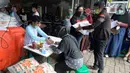 Warga mengantre untuk menerima dua paket sembako dari Kementerian Sosial dan Presiden di Kelurahan Pondok Benda, Tangerang Selatan, Minggu (25/10/2020). Paket sembako tersebut diberikan kepada 475 warga di seluruh Kelurahan Pondok Benda. (merdeka.com/Dwi Narwoko)