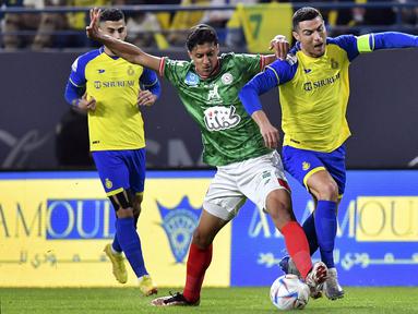 Pemain Al Nassr, Cristiano Ronaldo (kanan) berebut bola dengan pemain Al Ettifaq saat laga lanjutan Liga Pro Arab Saudi 2022/2023 yang berlangsung di Mrsool Park, Riyadh, Arab Saudi, Minggu (22/01/2023). Al Nassr menang dengan skor 1-0 dan kini menempati puncak klasemen sementara Liga Pro Arab Saudi 2022/2023. (AP Photo)