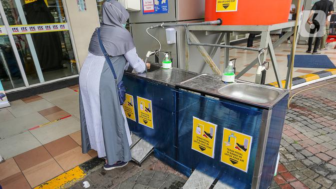 Pengunjung mencuci tangan dengan cara menginjak pedal sebelum masuk di pusat perbelanjaan ITC BSD Serpong, Tangerang Selatan, Selasa (16/6/2020). Menuju new normal, kawasan tersebut tetap menerapkan protokol kesehatan guna mencegah penyebaran Virus Covid-19. (Liputan6.com/Fery Pradolo)