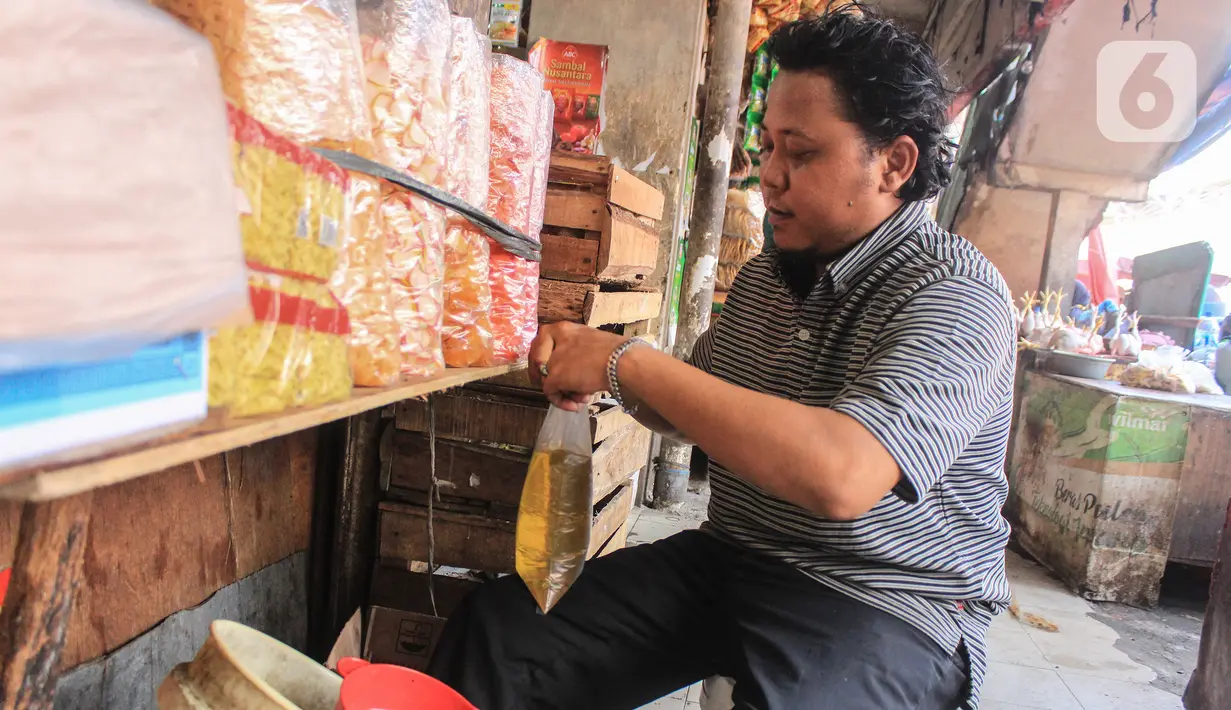 Pedagang memasukkan minyak goreng curah ke dalam kantong plastik di Pasar Kebayoran, Jakarta, Selasa (31/5/2022). Pencabutan menyusul dikeluarkannya Permendag Nomor 30 Tahun 2022 yang mengatur ketentuan ekspor CPO dan turunan lainnya dan Permendag Nomor 33 Tahun 2022 tentang Tata Kelola Minyak Goreng Curah Sistem DMO-DPO. (Liputan6.com/Johan Tallo)