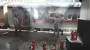 Petugas kereta api memadamkan api di gerbong kereta api di stasiun kereta api Secundrabad di Hyderabad, India, Jumat (17/6/2022). Ratusan pemuda melampiaskan kemarahan dengan membakar gerbong kereta, merusak properti kereta api dan memblokir rel dan jalan raya dengan batu-batu besar sebagai serangan balasan. (AP Photo/Mahesh Kumar A)