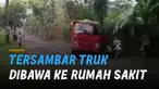 Ketika truk berwarna merah melintas, bokong truk itu mengenai salah satu perekam video.