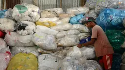 Pengumpul sampah memilih botol plastik di sebuah gudang sampah di Nusa Dua, di pulau resor Indonesia Bali (2/5). (AFP Photo/Sonny Tumbelaka)