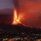 Lava mengalir dari gunung berapi saat terus meletus di pulau Canary La Palma, Spanyol, Selasa (26/10/2021). Aliran lava baru telah muncul setelah runtuhnya sebagian kawah dan mengancam akan menelan daerah yang sebelumnya tidak terpengaruh. (AP Photo/Emilio Morenatti)