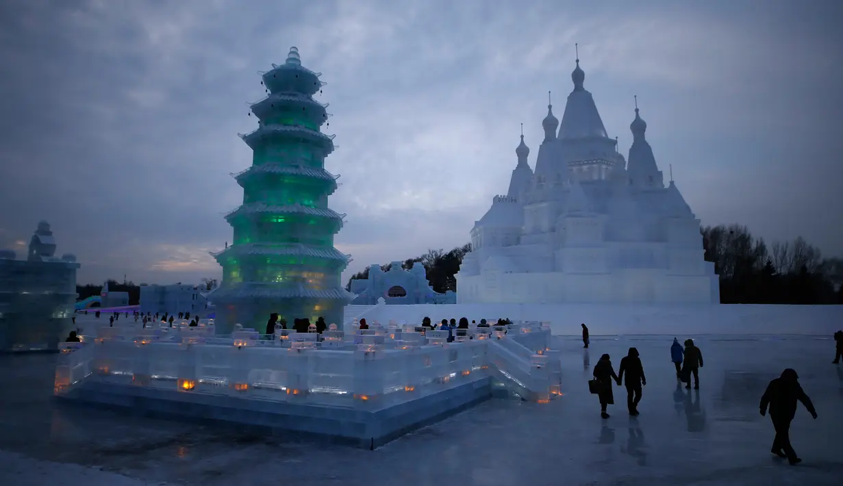 Sejumlah Pengunjung berjalan ditempat wahana es yang berda di kota utara Harbin, provinsi Heilongjiang , Cina, (5/1). Wahana ini dibuat menjelang festival Interrnasional es dan salju yang diadakan ditempat ini. (REUTERS/Aly Song)