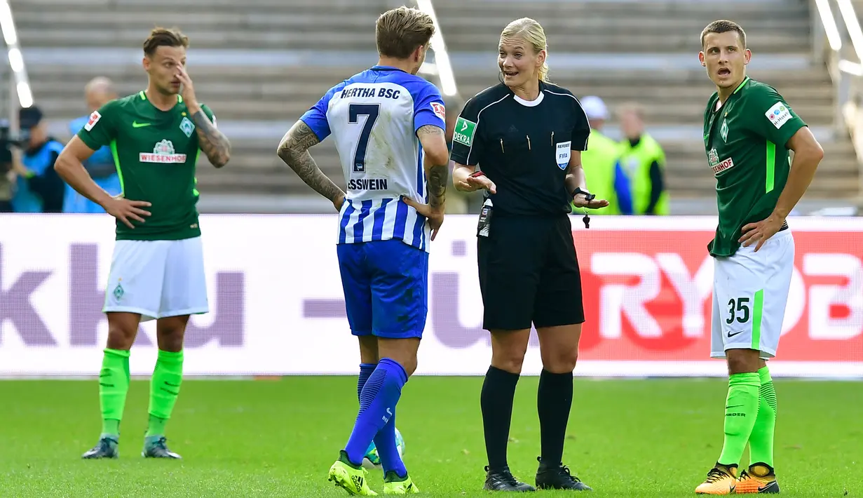Wasit, Bibiana Steinhaus berdebat dengan gelandang Hertha Berlin, Alexander Esswein dan gelandang Werder Bremen, Maximilian Eggestein saat pertandingan Bundesliga Jerman di Berlin (10/9). (AFP Photo/Tobias Schwarz)