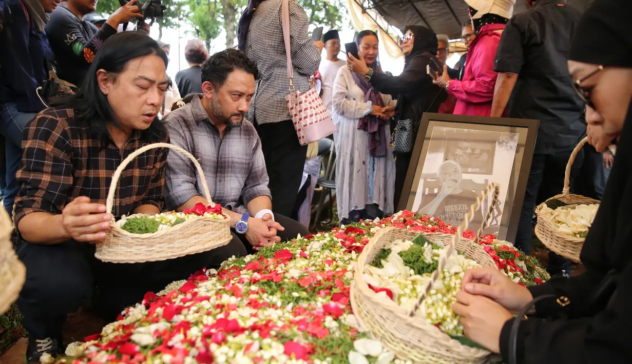 Pihak keluarga menabur bunga di pusara Nomo Koeswoyo. Setelah itu, beberapa kerabat dan sahabat juga menabur bunga dan mendoakan Nomo Koeswoyo. [Foto; Adrian Putra/Fimela.com]