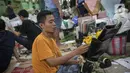 Perajin menata buket atau karangan bunga di Pasar Bunga Rawa Belong, Jakarta, Senin (14/2/2022). Dari 50 paket menjadi 25 paket atau turun 50 persen per minggu dibandingkan sebelum Covid-19. (Liputan6.com/Faizal Fanani)