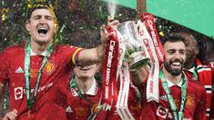 Pemain Manchester United, Harry Maguire (kiri) dan Bruno Fernandes mengangkat trofi bersama-sama setelah memenangkan final Carabao Cup 2023 melawan Newcastle United yang berlangsung di Wembley Stadium, Minggu (26/2/2023) waktu setempat. (AP Photo/Alastair Grant)