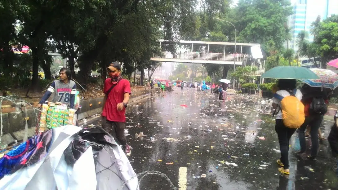 Pasukan Pelangi membersihkan sampah usai demo buruh (Liputan6.com/ Ahmad Romadoni) 