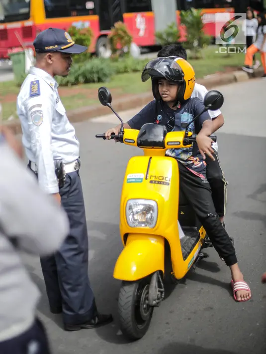 Petugas Dishub mensosialisasikan kepada pengendara sepeda motor listrik Migo saat melintasi CFD di kawasan Bundaran HI, Jakarta, Minggu (17/2). Penyewa sepeda motor listrik dihimbau untuk tidak melintasi jalan raya. (Liputan6.com/Faizal Fanani)