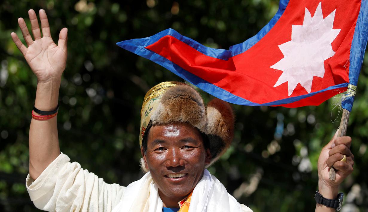 Pendaki asal Nepal, Kami Rita Sherpa melambaikan tangan setelah turun dari Gunung Everest di Kathmandu, Nepal, Sabtu (25/5/2019). Pria berusia 49 tahun tersebut mencetak rekor dengan mendaki Gunung Everest sebanyak 24 kali. (REUTERS/Navesh Chitrakar)