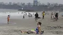 Pengunjung pantai menghabiskan waktu di pantai Agua Dulce di Lima, Peru, Kamis (30/12/2021). Pemerintah Peru mengumumkan penutupan pantai untuk 31 Desember - 1 Januari sebagai langkah untuk membantu mencegah penyebaran virus corona. (AP Photo/Guadalupe Pardo)