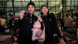 Dua pemain Timnas voli putri Indonesia U-18, Poppy Aulia Nursutan (kiri) dan Venisa Dwi Oktani berpose dengan medali perak turnamen bola voli putri Princess Cup 2024 dalam acara penyambutan di Terminal 3 Bandara Soekarno Hatta, Tangerang, Jumat (14/6/2024). (Bola.com/Bagaskara Lazuardi)