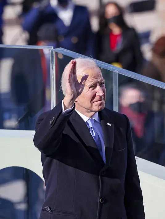 Presiden Joe Biden melambaikan tangan ketiak bersiap untuk menyampaikan pidato pelantikannya di Front Barat Capitol AS di Washington, Rabu (21/1/2021). Joe Biden mengalahkan Donald Trump di pemilu AS 2020 dengan perolehan 81 juta suara. (Tasos Katopodis/Pool Photo via AP)