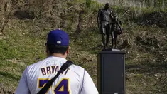 Oscar Romero berdiri dekat patung untuk mengenang Kobe Bryant dan putrinya, Gianna di Calabasas, California, Rabu (26/1/2022). Patung itu dibawa seniman Dan Medina, di jalan setapak dekat lokasi Bryant, putrinya dan tujuh orang lainnya tewas dalam kecelakaan helikopter pada 2020. (AP/Ashley Landis)