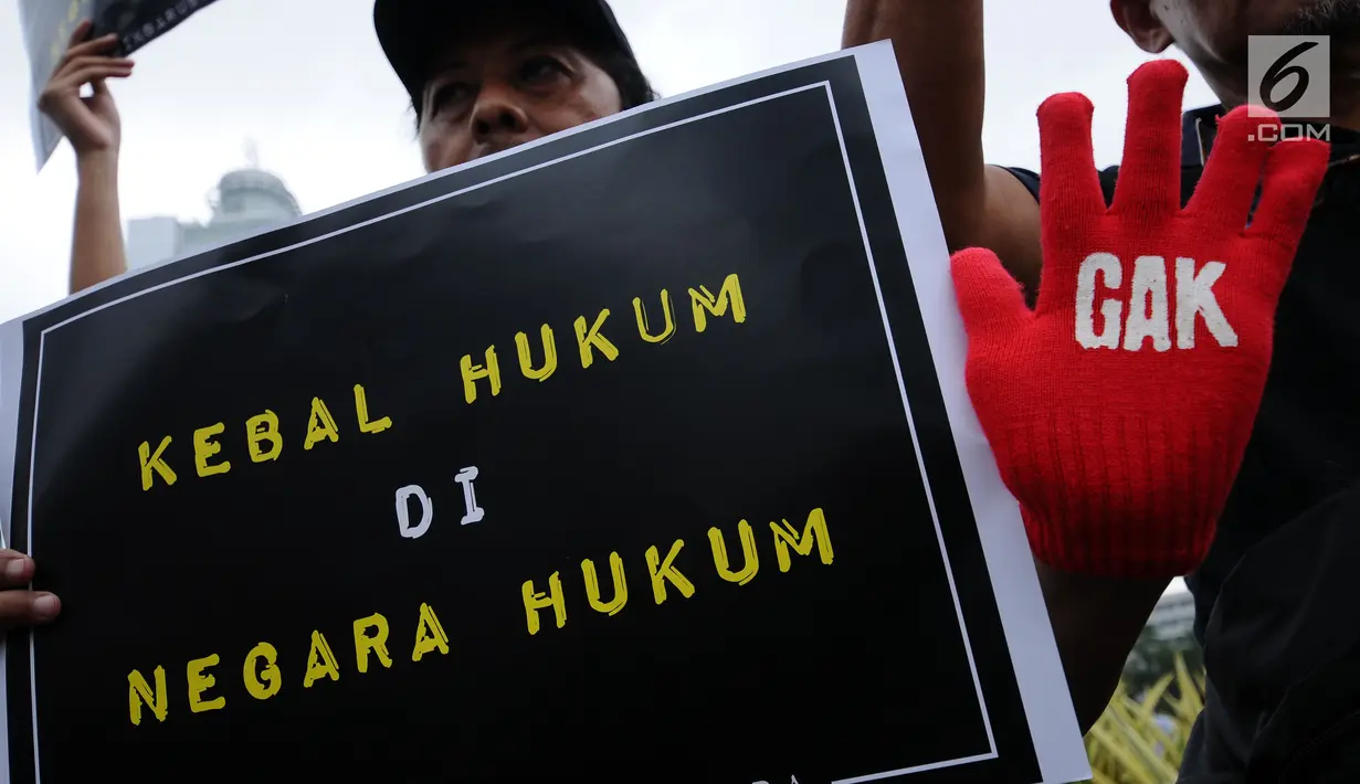 Aktivis Koalisi Masyarakat Sipil Anti Korupsi menunjukkan tulisan saat aksi Indonesia Berkabung di kawasan Bundaran HI Jakarta, Minggu (1/10). Aksi ini reaksi menyikapi dicabutnya status tersangka Setya Novanto. (Liputan6.com/Helmi Fithriansyah)